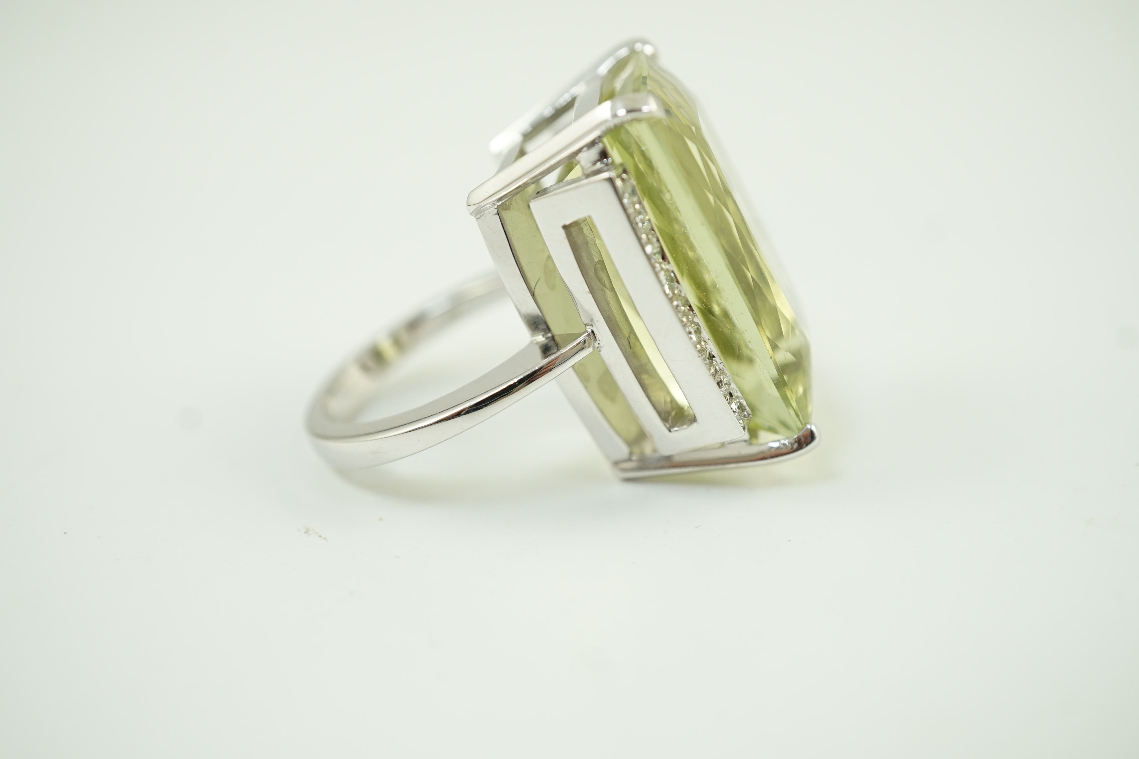 A modern white gold and shaped rectangular fancy cut pale green beryl set dress ring, with diamond chip setting